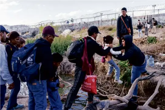  ?? PAUL RATJE/THE NEW YORK TIMES ?? Migrants crossed the Rio Grande to a camp at the US southern border, near Ciudad Juarez, Mexico, on Tuesday.