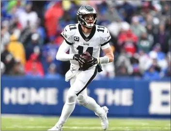  ?? ADRIAN KRAUS — THE ASSOCIATED PRESS ?? Eagles quarterbac­k Carson Wentz rolls out in Sunday’s 31-13victory over the Buffalo Bills. The numbers show that Wentz is a more accurate passer on the move.