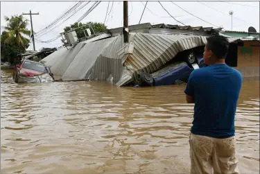  ?? THE ASSOCIATED PRESS ?? A resident looks at damage caused by Hurricane Eta in a neighborho­od of Planeta, Honduras, Nov. 6. As the remnants of Hurricane Eta moved back over Caribbean waters, government­s in Central America worked to tally the displaced and dead, and recover bodies from landslides and flooding that claimed dozens of lives from Guatemala to Panama.