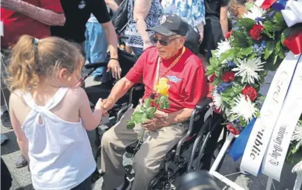  ?? Chip Somodevill­a, Getty Images ?? A little girl shakes hands with World War II veteran Jose Baldonado during a wreath laying ceremony Thursday at the National World War II Memorial in Washington, D.C., on the 75th anniversar­y of D-Day.