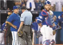  ?? Frank Gunn / Associated Press ?? Toronto manager John Gibbons argued with home plate umpire Dale Scott for a dead-ball call — to no avail — when catcher Russell Martin’s throw struck Shin-Soo Choo’s bat.