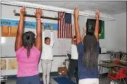  ?? MICHILEA PATTERSON — DIGITAL FIRST MEDIA ?? Students raise their hands to the sky as part of a stretch during a yoga club at Pottstown Middle School.