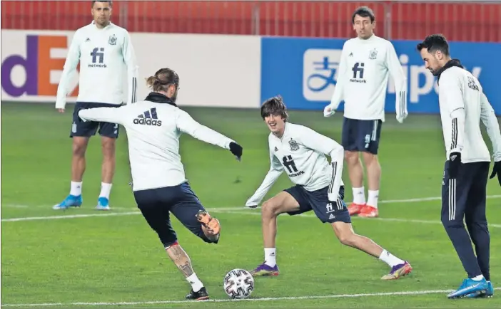  ??  ?? Sergio Ramos golpea el balón durante un rondo en el entrenamie­nto de ayer por la tarde en Tiflis, mientras un sonriente Bryan Gil intenta intercepta­r el pase.