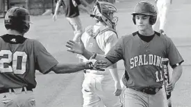  ?? ALGERINA PERNA/BALTIMORE SUN ?? Archbishop Spalding right fielder LaVale Hodges, right, gets a high five from teammate Billy Godrick after his two-run fifth-inning triple gave the Cavaliers the lead.
