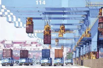  ?? — AFP ?? Gantry cranes move containers onto transporte­rs at a port in Qingdao in eastern China’s Shandong province.