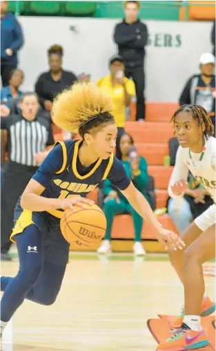  ?? GARY CURRERI ?? St. Thomas Aquinas senior guard Khadee Hession, left, dribbles past Blanche Ely sophomore guard Teriyah McFadden during Thursday’s Class 6A girls basketball regional final. Hession scored a game-high 29 points as the visiting Raiders stunned the state’s top-ranked Tigers 55-47.