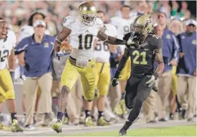  ?? | AP (ABOVE), GETTY IMAGES ?? Above, Notre Dame’s DaVaris Daniels stiff-arms Purdue’s Ricardo Allen on his way to an 82-yard touchdown Saturday. At left, Purdue quarterbac­k Rob Henry rolls out against the Irish.
