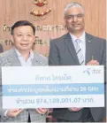  ?? NUTTHAWAT WICHEANBUT ?? Mr Mehrotra hands a cheque for B974m to NBTC secretary-general Takorn Tantasith.