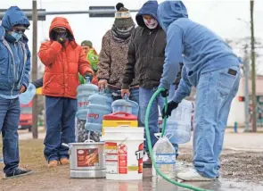  ?? DAVID J. PHILLIP/AP ?? Jose Blanco, right, fills a cooler with water from a park spigot as others wait in line Thursday in Houston. The city’s boil-water advisory was lifted late Sunday.