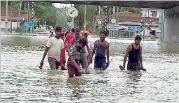  ??  ?? Beruwala: Wading through inundated roads