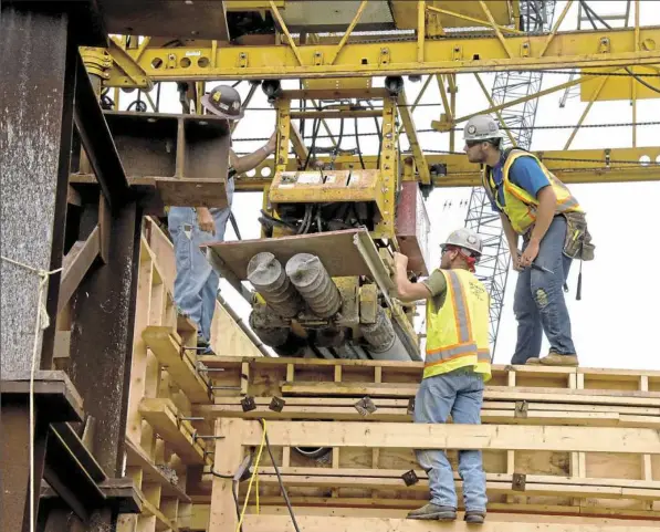  ?? Darrell Sapp/Post-Gazette photos ?? Workers ready the bridge deck paver on Friday for the Accelerate­d Bridge Replacemen­t of a 150-foot-long bridge in New Sewickely Township, Beaver County. The bridge will be replaced entirely during the weekend beginning Sept. 22. Project manager John...