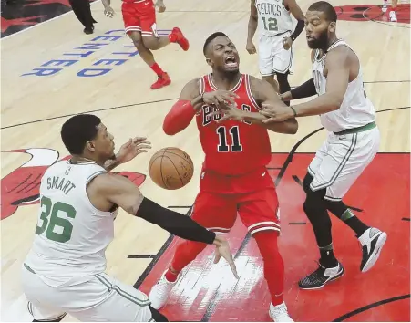  ?? AP PhOTO ?? DEFENSIVE POSTURE: Marcus Smart and Greg Monroe combine to strip the ball from David Nwaba (11) during the Celtics' win over the Bulls last night in Chicago.