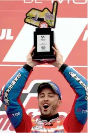  ??  ?? Ducati’s Andrea Dovizioso poses with the trophy after winning the Japan Moto GP on Sunday. —