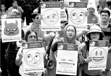  ?? — Reuters photo ?? Various activists groups hold emoji-riddled placards as they join other protesters in airing their individual concerns marking Duterte’s first year in office during a protest outside the presidenti­al palace in metro Manila, Philippine­s.