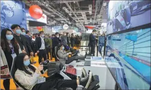  ?? ZHAI HUIYONG / FOR CHINA DAILY ?? Visitors check out video games on ABB simulators during the third China Internatio­nal Import Expo in Shanghai in November.