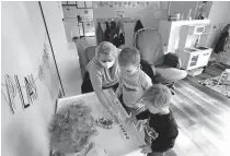  ?? [DAN POWERS/USA TODAY NETWORK] ?? Nicole Leitermann helps Burke Miller, 2, left; Ethan Miller, 3; and Henry McSorley, 2, during a math activity Nov. 2 at Impression­s Family Child Care in Kimberly, Wis.