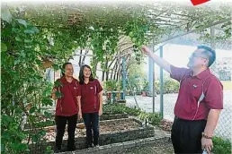  ??  ?? 黄源钟（右起）和美化组组长黄惠卿及­家协理事林秋芬巡视绿­园的蔬果。