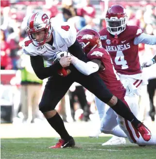  ?? Michael Woods/Associated Press ?? ■ Western Kentucky quarterbac­k Ty Storey is tackled by Arkansas defender Montaric Brown as he runs the ball down to the goal line on Nov. 9, 2019, in Fayettevil­le, Ark.