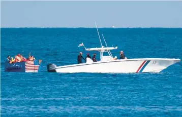  ?? YAMIL LAGE/AFP ?? Cuba’s coast guard tows a handmade raft with an American flag painted along the bow on Monday.