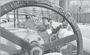  ?? TONG JIANG / FOR CHINA DAILY ?? Employees of China Petroleum & Chemical Corp check natural gas pipelines in Puyang, Henan province.