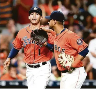  ?? Karen Warren / Houston Chronicle ?? Shortstop Carlos Correa, left, celebrates a defensive gem with Yulieski Gurriel on Saturday night.