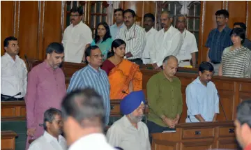  ?? — BUNNY SMITH ?? Chief minister Arvind Kejriwal, deputy chief minister Manish Sisodia and other legislator­s observe a moment’s silence for the victims of recent earthquake in India and Nepal during the special session of the Assembly in New Delhi on Tuesday.