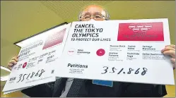  ?? AP ?? A representa­tive of an anti-olympics group holds boards showing the number of people who have signed a petition calling for the cancellati­on of Tokyo 2020.