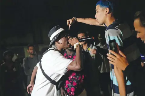  ?? (AP/Silvia Izquierdo) ?? Real Hoppe (left) and Kunk compete Wednesday during the Gas Battle rapping event outside a bar in the City of God favela of Rio de Janeiro.