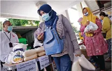  ?? DIPTA WAHYU/JAWA POS ?? BANTU SELAMA PANDEMI: Warga membeli sembako murah saat bazar Bulog. Khusus PPKM darurat, Bulog mendistrib­usikan 31 ribu ton beras.