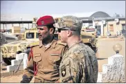  ?? 1ST LT. DANIEL JOHNSON / U.S. ARMY ?? U.S. Army Capt. Gerrard Spinney (right), commander of Company C, 1st Squadron, 75th Cavalry Regiment, speaks to his Iraqi army counterpar­t at Camp Swift, Iraq, as the groups that make up Iraq’s security forces converge on Mosul.