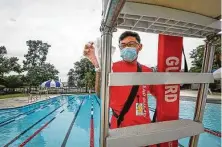  ?? Steve Gonzales / Staff photograph­er ?? Piero De la Torre, pool manager at the D. Bradley McWilliams YMCA at Cypress Creek, disinfests the lifeguard station.