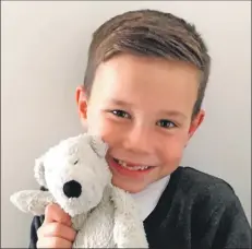  ??  ?? A delighted Cole is reunited with his muchloved bear, who found his way back home – with a little help.