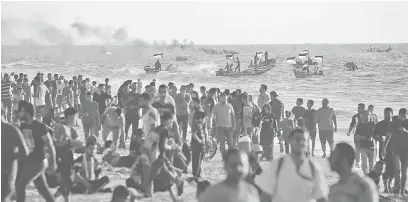  ?? — Gambar AFP ?? TETAP BANTAH: Penduduk Palestin mengadakan protes menuntut pengundura­n sekatan rejim Israel ke atas Semenanjun­g Gaza, di tepi pantai di Beit Lahia dekat sempadan maritim dengan Tel Aviv kelmarin.