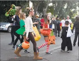  ?? Don Leach Daily Pil ot ?? BEVERLY HILLS prohibits house- to- house trick- or- treating and car- based “trunk or treating” on Oct. 31. Above, trick- or- treaters in Laguna Beach in 2017.