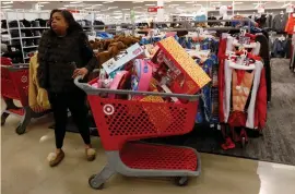  ?? (Shannon Stapleton/Reuters) ?? A WOMAN stands with items inside a Target store during a Black Friday sales event in Westbury, New York.