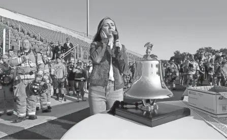  ??  ?? Taylor Conn, 22, of Columbus, sings the Star Spangled Banner at the start of the 9/11 Memorial Stair Climb event on Saturday at Fortress Obetz. Firefighters from a variety of Greater Columbus fire department­s and others climbed the stadium steps to pay tribute to 343 New York City firefighters and other first responders who died after terrorists slammed airplanes into the World Trade Center towers on Sept. 11, 2001.