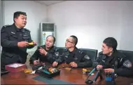  ??  ?? Yan (right) discusses bomb-disposal skills with colleagues in the Beijing Public Security Bureau’s counterter­rorism department.