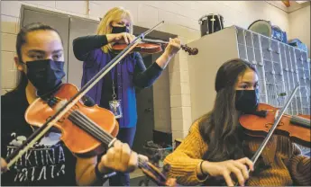  ?? NATHAN BURTON/Taos News ?? Rachel Leon, musical director for Questa Independen­t Schools, middle, plays the violin with students during mariachi band rehearsal Monday (Nov. 8) at Questa Junior/Senior High School.