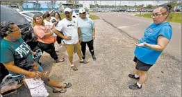  ?? ROGELIO V. SOLIS/AP ?? Gabriela Rosales, right, confers with friends Thursday outside the employee entrance to the Koch Foods Inc., plant in Morton, Miss. Federal agents raided the plant Wednesday.