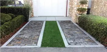  ?? MARGARET MAYFIELD/THE ASSOCIATED PRESS ?? This permeable driveway is a combinatio­n of grass and pavers.