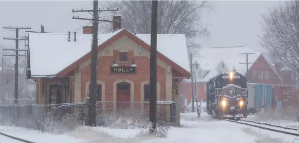  ?? ?? Led by a pair of SD40s, train Z127 passes the former joint Pere Marquette/Grand Trunk Western depot in Holly on a snowy Jan. 26, 2021.