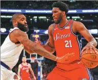  ?? MIKE STOBE / GETTY IMAGES / AFP ?? Joel Embiid of the Philadelph­ia 76ers fends off Kyle O’Quinn of the New York Knicks during the Sixers’ 105-98 victory at Madison Square Garden on Monday.