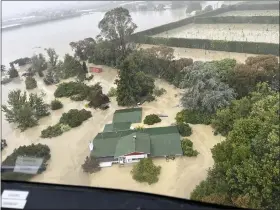  ?? NEW ZEALAND DEFENSE FORCE VIA AP ?? In this image released by the New Zealand Defense Force on Wednesday, people stand on a rooftop of a home waiting to be winched to safety by helicopter in the Esk Valley, near Napier, New Zealand.