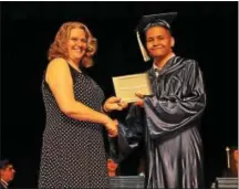  ??  ?? Heather Saboori, parent representa­tive on the board of directors congratula­tes 21st Century Cyber Charter School graduate Joshua Martin Chappelle.