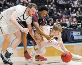  ?? Mark Humphrey ?? The Associated Press Texas Southern’s Demontrae Jefferson, center, is crunched between Xavier’s Sean O’mara and J.P. Macura, right, in a battle for a loose ball.