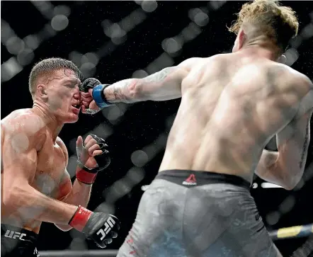  ?? AP ?? Kiwi Shane Young, left, takes a hit to the face from Austin Arnett of the US during their featherwei­ght bout.