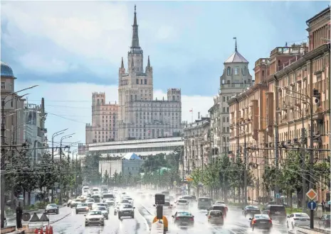  ?? MLADEN ANTONOV, AFP/GETTY IMAGES ?? Cars pass along Moscow’s Garden Ring, which is overlooked by Stalin-era structures. Efforts to restore the gardens that gave the road its name cause daily gridlock because of detours and constructi­on.