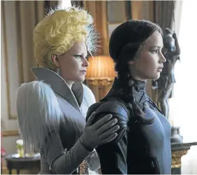  ??  ?? STYLE SCHOOL: Elizabeth Banks as Effie Trinket and Jennifer Lawrence as Katniss Everdeen