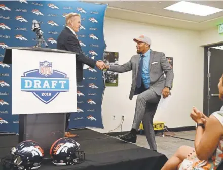  ?? Andy Cross, The Denver Post ?? Broncos general manager John Elway brings the Broncos’ first-round draft pick, defensive end Bradley Chubb, to the podium to visit with the news media gathered at Dove Valley on Friday.