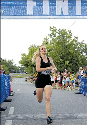  ?? Arkansas Democrat-Gazette/STATON BREIDENTHA­L ?? Cheryl Nolan of Jonesboro crosses the finish line on North Monroe Street near War Memorial Stadium in Little Rock to win the women’s division of the Firecracke­r Fast 5K on Tuesday with a time of 16 minutes, 58.69 seconds.